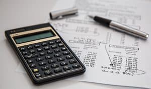 A calculator laying beside some accounts